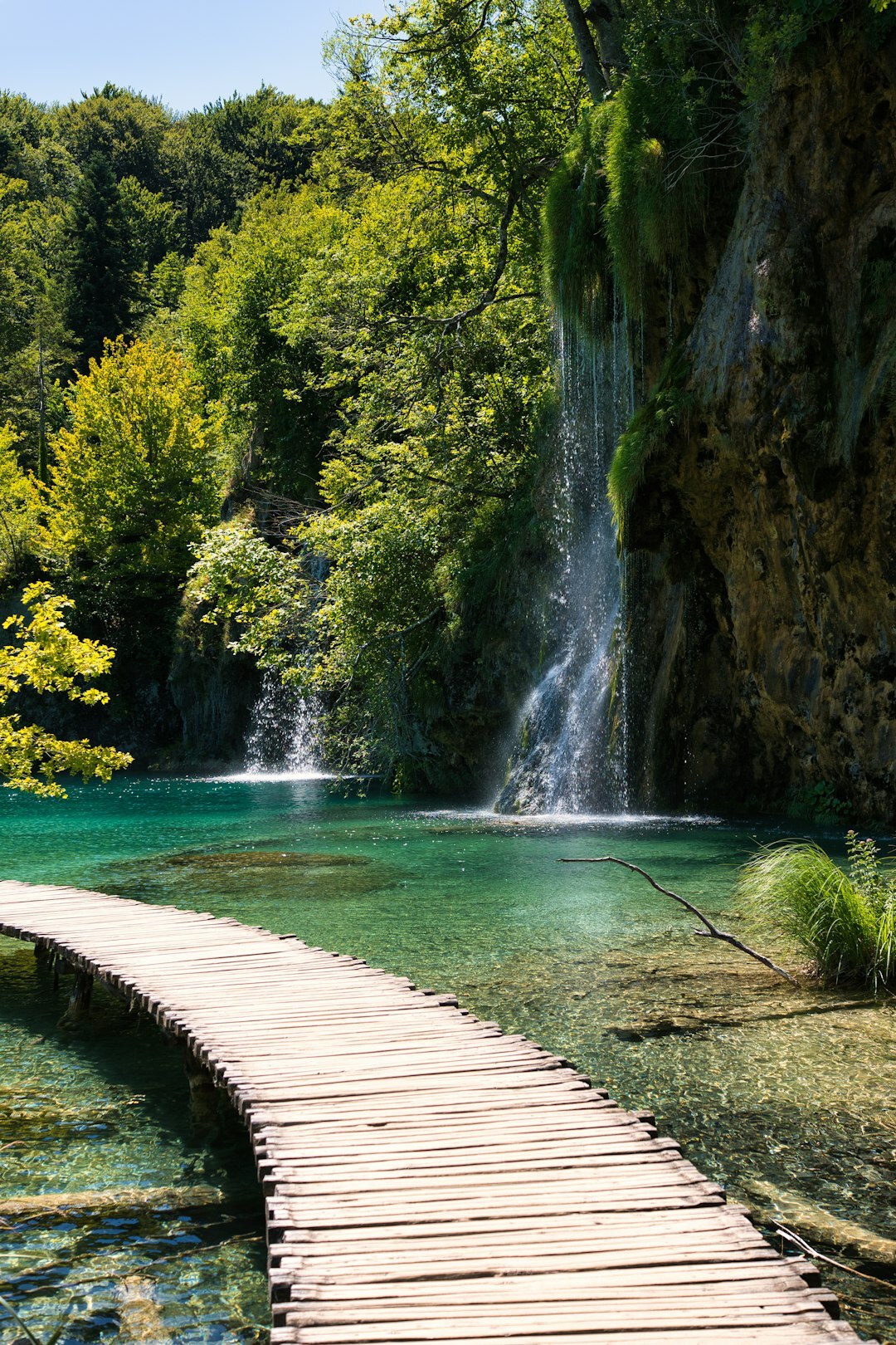 Seniors walking on a wooden boardwalk at Plitvice waterfalls