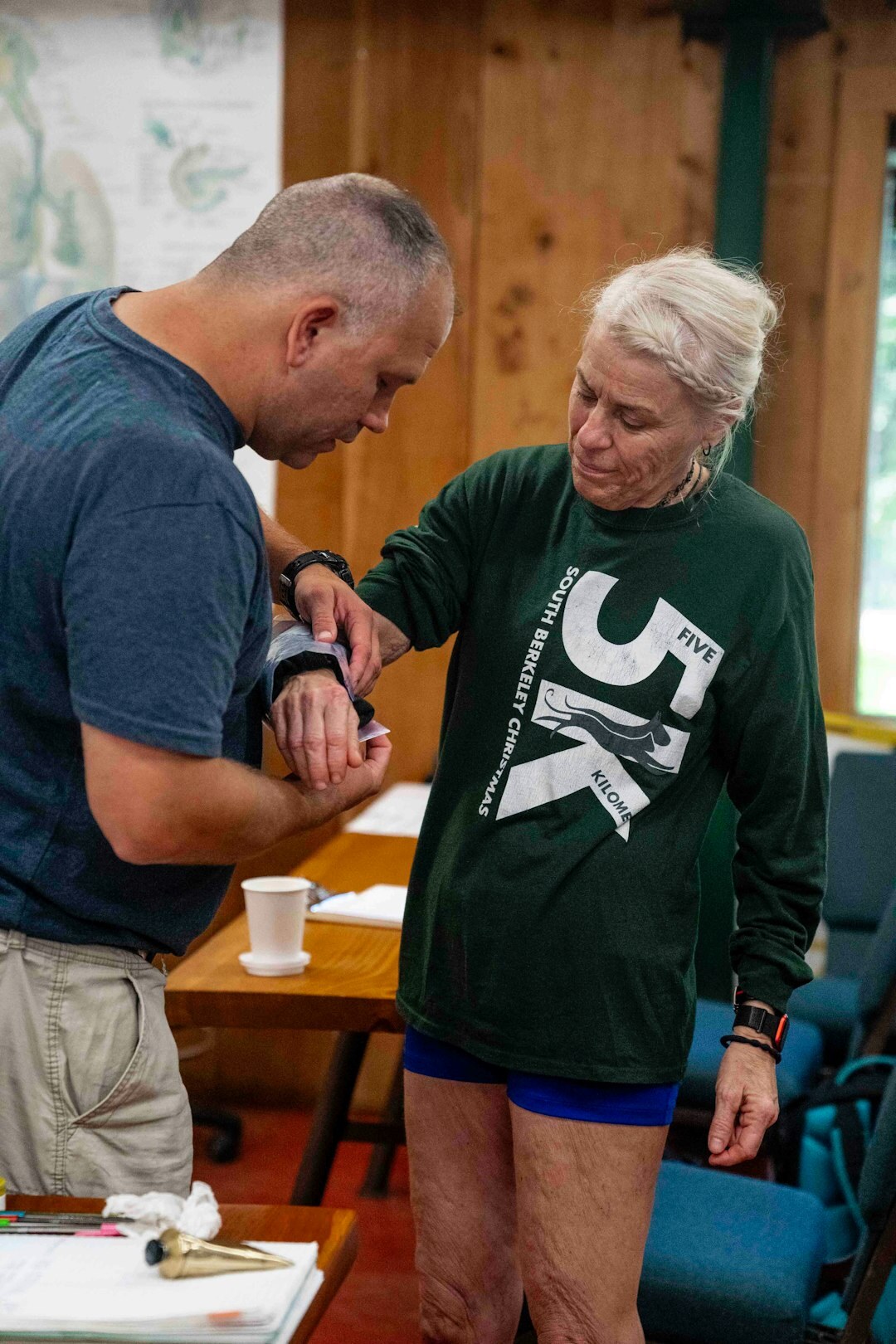 Staff member helping a senior woman fill out a registration form